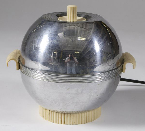 Russel Wright for Chase Chrome Chaffing Dish: Ball form chrome with bakelite handles, top of lid and base. Insert is Pyrex glass in fishbowl shape. 9.25" H x 8.5" Dia.; marked Chase on the back and again on large screw inside. Surface scratches t