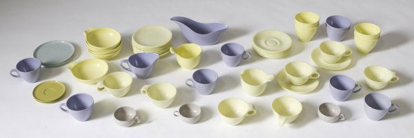 24 Russel Wright "Residential" Yellow Dinnerware: Each plastic, and marked "Russel Wright Residential by Northern Boston 27" and includes 7 cups, 8 saucers, 8 cake plates, and a creamer, together with 4 yellow pudding bowls, 5 bowls, and a creamer ea