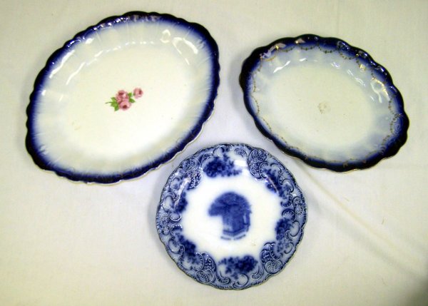 3 Flow Blue Porcelain Articles: To include a Blarney Castle surrounded by raised scrolling and blue leaf designs, 10" Dia.; signed Woodson & Son, England. Together with 2 La Francaise Porcelain platter. Smaller with blue and gilt fl