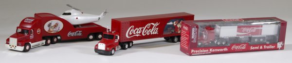 3 Coca-Cola Trucks: To include a "Christmas Caravan" truck with lights, in box. A Precision Kentworth "Semi & Trailer" in box. And a 2000 "Holiday Helicopter Carrier" in box. All in excellent condition.