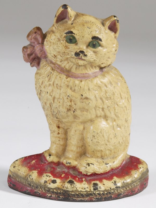 Antique Cast Iron Cat Doorstop: Cat with a pink bow standing on a base. All original paint, marked 800 on back. 7.5" H x 6" W. Paint loss consistent with age.