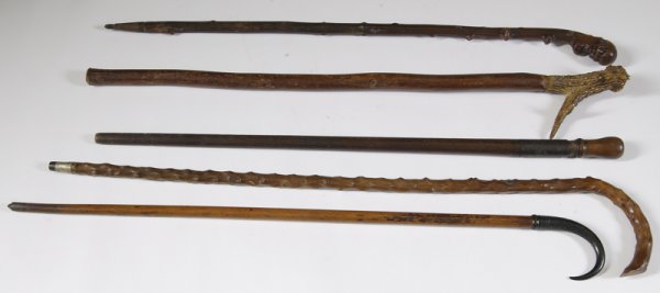 Collectors Lot of 5 Vintage Walking Sticks / Canes: One stag horned handle cane; one curved horned handle cane; 2 made from knotty wood and 1 dagger cane. Size: All approximately 36" H. Condition: All show use and wear consistent with age.