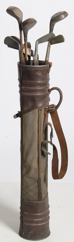 Antique Golf Bag and Golf Clubs: Circa 1920's, bag made by Cupples Rhino E & H and is cylindrical made from canvas and leather. Together with 11 wooden handled golf clubs, ranging in different sizes. Missing pocket from bag, and club