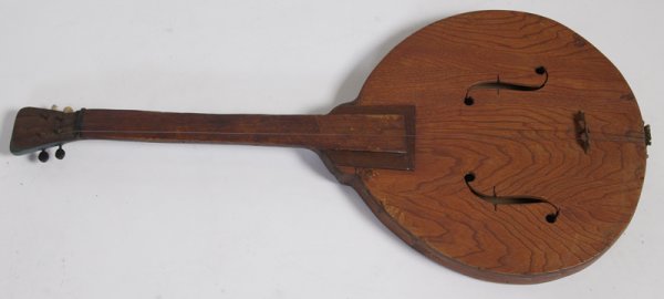 Handmade Folk Banjo: Large banjo pot with hand carved designs. Shorter neck. Entire banjo is stained red with green paint added to top. Additional wall hanger on top. 3 strings attached. 33.25" L; some separation in wood 