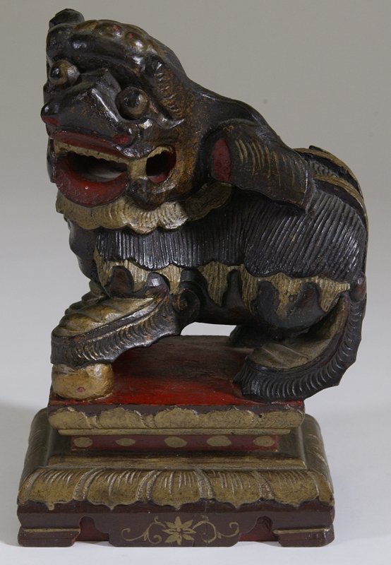 Early 20th C. Carved & Painted Wood Foo Dog: Detailed Foo Dog with large mouth, and turned body atop a pedestal. Painted in red, gold and dark brown. 9.75" H x 6.25" W x 4.25" D. Surface crack on bottom extending up through pedestal in back. Pri