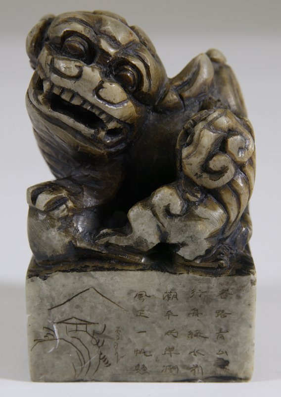 Chinese Soapstone Carved Foo Dog Seal: Soapstone seal with carved foo dog and possibly a smaller foo dog on base with landscape etchings and wording on one side. Seal on bottom is 4 character mark with remnants of red ink. 3 & 2/8" H x 2"