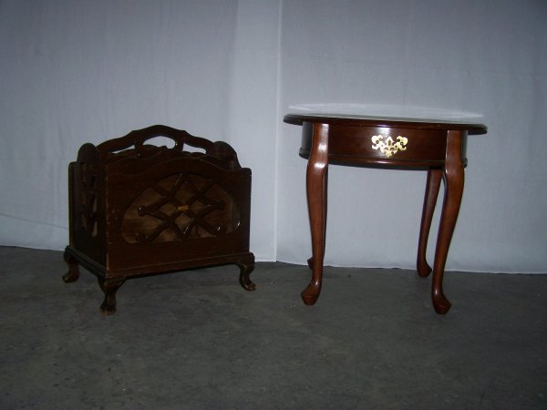 End Table And Carved Wood Magazine Stand: Round mahogany shade end table with front brass accent along with a carved wood four slot magazine stand with handle. End table measures approx. 22" high, magazine stand measures approx. 20" high to t