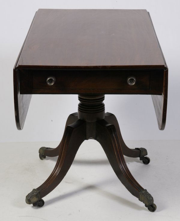 Fine Regency Mahogany Drop Leaf Table: Regency mahogany supper table, with drop leaf and one real and one dummy frieze drawer. Turned baluster column on four reeded down-swept legs with brass capping and castors. Dimensions are approx. 43"
