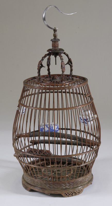 Chinese Bird Cage with Porcelain Feeders: Antique Chinese bamboo bird cage has three porcelain blue and white feeders. Three wood perches inside and open carved woodwork to feet. Large metal hook for hanging .Measures approx. 26" high. Porcel