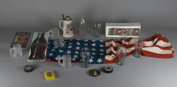 18 Piece Coke® and Memorabilia Items: Includes 4 coke glasses, a coke stein, a coke glass bottle, a coke hanging sign, a pack of coke playing cards, 6 coke coasters, 4 McDonalds Batman glass mugs, 2 hockey pucks, a Jeff Gordon license pla