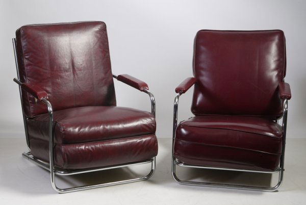 Gilbert Rohde for Troy Sunshade Chrome Chairs: Circa 1930's, slant back chrome frames with leather upholstered backs, seats, and arm rests, each chair measures 32"H x 24"W x 33"D. One chair has a 4" slice on the back side of the back cushion and t