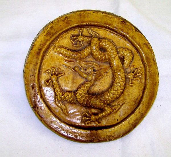 Exceptional Ming Dynasty Forbidden City Roof Tile: Rare, circular tile with raised border, centered by a Imperial 5-toed dragon with highly detailed scales on its' body. All in a fine Imperial yellow glaze. The tile retains 2 early paper labels. First