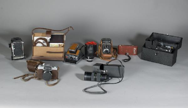 Grouping of Vintage Cameras & Accessories: Includes a Mamiya C220 camera, a Macro lens and case, a Yashica-A camera, a Nikkorex camera, a Polaroid SX-70 camera in case with flash and film, a miniature projector in case, a Rainbow Hawk-Eye no.