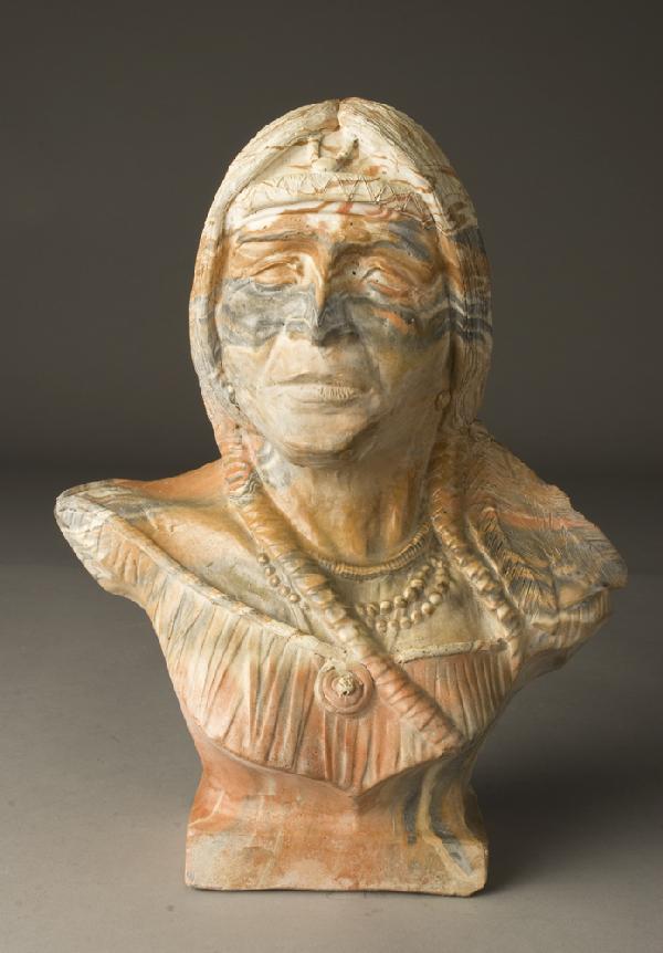 Late 20th C. Comanche Pottery Bust of Indian: Bust of Indian glancing to the right in colors of orange, gray, and tan. 11" H x 8.5" W, signed Comanche Pottery Tx. By Don Juan on back, small chip to neckpiece in back. Private collection Warren, Mi