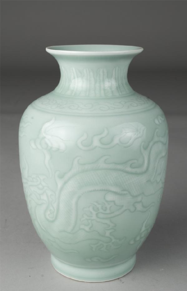 Chinese Qing Celadon Glazed Dragon Vase: The baluster shaped vase finely incised with two five clawed dragons chasing flaming pearls, amidst scattering ruyi, the neck with stiff petals, the shoulder with a band of ruyi. Yongzheng seal mark i