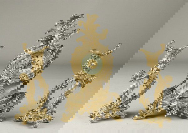 (3) Piece Ansonia Garniture Set: Includes clock, and two candlesticks, all with cherub, scrolling and leaf decorations with harps, cups and flowers. Clock measures 10" H, top cherub lacking left hand. Candlesticks measure 7.25" H, on