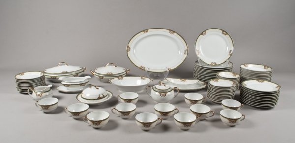 (96) Pieces of Fine Porcelain, Probably Nippon: The rim decorated with green, yellow and emerald geometric designs with various placed cartouches of floral bouquets. The edges and handles richly gilded. Includes a covered sugar bowl, a creamer, a c