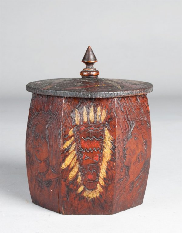 Fine Native American Carved & Painted Humidor: Finley carved and painted to depict bow quivers, indians, beaded bags, tomahawks,spears, and war shields, the finial in the shape of a teepee, the lid and sides both decorated, 6.5"H, circa 1890 to 19