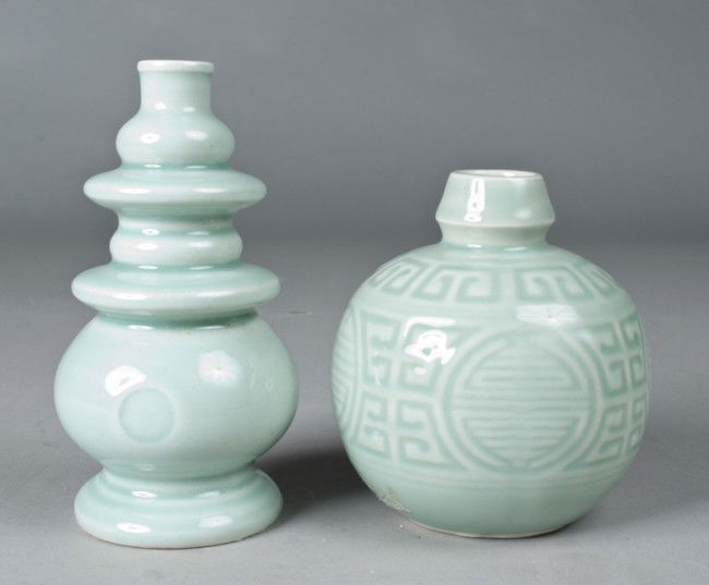 (2) Chinese Celadon Vases: Includes a round vase with symbols and Greek key designs, 5" H x 4.5" W, five character mark within a circle on underside, possibly lacking a stopper. Together with a gourd shape with pyramid ribbing,