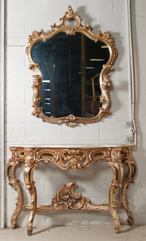 A Fine Gilt Wood Marble Top Table and Mirror: Decorated in the Rococo taste table measures 52"W X 16"D, mirror measures 51"H X 39"W, circa 20th Century. Excellent condition.