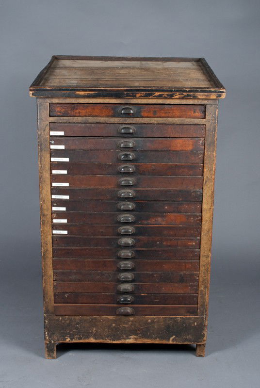 A Fine American 17 Drawer Printers Cabinet: With slant top, featuring 17 drawers with original pulls, the sides with recessed panels, 48"H x 27.5"H x 20" D, circa 1900.