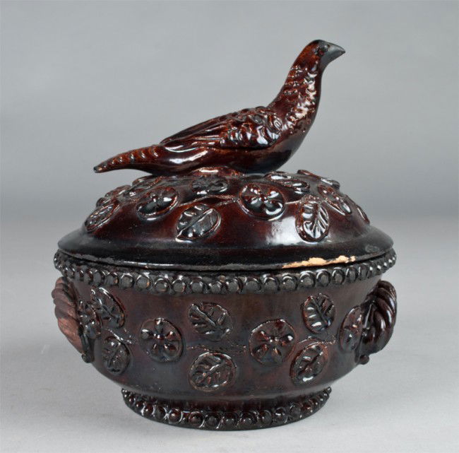 A Fine Signed And Dated Redware Covered Dish: Finley molded to depict flowers and beadwork, with a large dove finial, signed under lid Elisabeth Kaiser and dated 1890, 8.5"H x 7.5"D, American or continental, a couple small chips to lid edge.