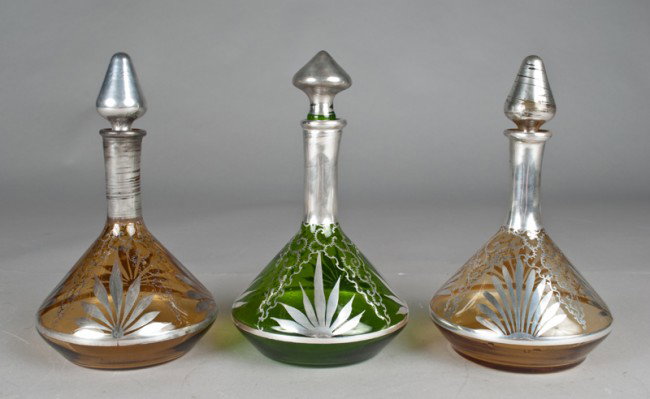 (3) Silver Overlay Colored Glass Decanters: One in green glass, and two in amber, all with polished pontils, and stoppers, one amber with wear, the other two are excellent, all circa 1880's, all 9.5"H.
