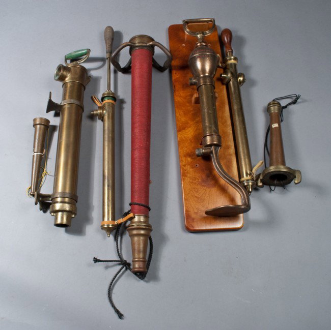 (7) Antique Brass Fire Pumps and Nozzles: Includes a pump by H.D. Edwards & Co., mounted on wood plaque, two nozzles, a pump wrapped in red string, two smaller pumps with wood handles, and a large pump impressed with "Series B." Longest measu