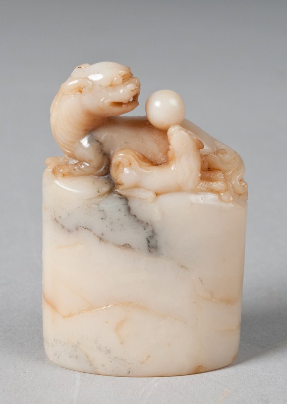 Very Fine Chinese Soapstone Seal: Extremely fine carving in soapstone of a mother and baby foo dog with ball. A unique oval shape. The stone a creamy celadon color with russet inclusions. 2.625" H, 19th Century. Private collection Tro