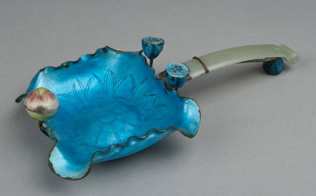 Chinese Jade And Enamel Lotus Shaped Dish: The lotus shaped dish in blue enamel with pods and buds, with nephrite jade handle finely carved with a Shou symbol and bat at the end of the scroll shaped handle, further adorned with a molded insect
