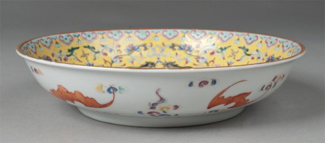 Chinese Famille Rose Low Bowl: Finely enameled interior with various flowers, scrolling and chi long designs, while exterior painted with bats amid ruyi. Six character mark in iron red for Great Qing Qianlong Production on undersid