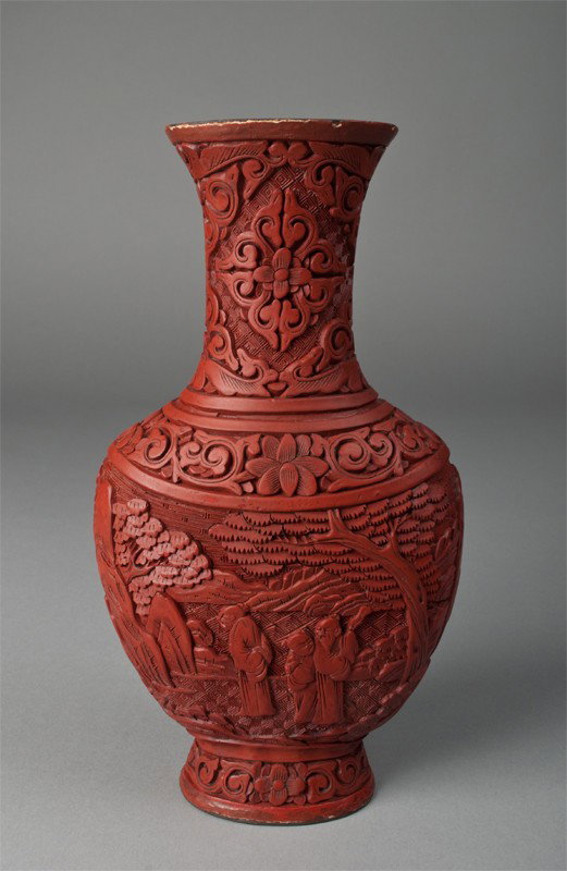 A Fine Chinese Cinnabar Lacquer Vase: Flat vase and deeply carved depicting figures in landscapes to either side, with floral and scrolling in remainder. 10" H, marked China on underside. Some losses to rim. Late 19th/early 20th century.