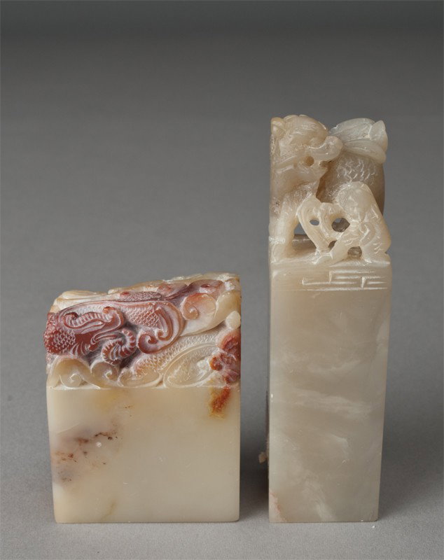 (2) Chinese Carved Soapstone Seals: One carved to depict a foo lion with baby, 3.5"H, the other carved to depict coiled dragon 2.25"H, circa 20th century.