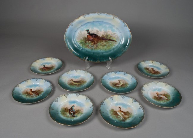 (9) Pieces Bavarian Porcelain Game Platter/ plates: Includes a large platter decorated with a standing pheasant amongst foliage, 17"L, together with eight plates decorated the same, 8.5"D, circa early 20th century.