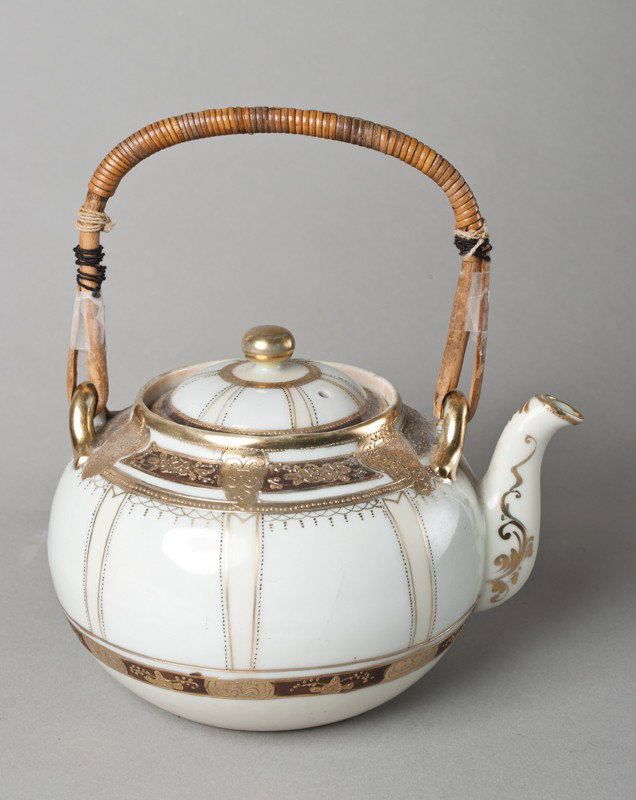 Nippon Tea Pot With Strainer: Heavily gilded with art deco designs, signed with green mark, with original porcelain strainer and bamboo handle, 8"H to top of handle, slight wear to gilt, circa 1920, very nice piece.