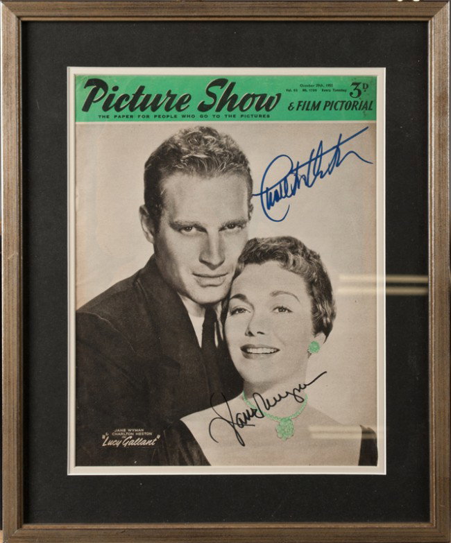 Charlton Heston & Jane Wyman Autographs: Both autographs on Picture Show & Film Pictorial with image of the two; signed in blue Carleton Heston in UR, singed in black Jane Wyman in LR. Matted and framed behind glass, 16.5" H x 13.5" W, inclu