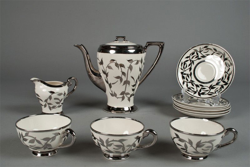Myott England Silver Lustre Partial Tea Set: Includes a coffee pot, a creamer, three cups and six saucers, with silver overlay in floral designs. Some pieces marked with Myott England on underside. Tallest 7.75" H, small chip on bottom of creame