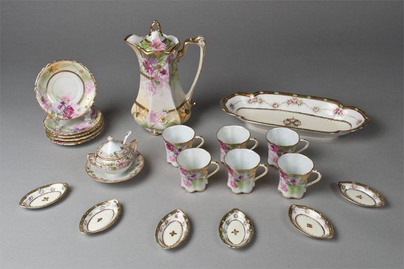 A Fine Nippon Celery & Chocolate Set: Includes a celery set with celery tray and six salt dips, finely painted in pink roses with heavy gilt beading and designs to center; all with green wreath mark. Together with a chocolate pot, six cup