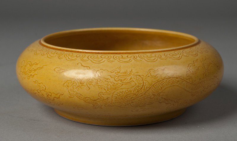 Chinese Molded Porcelain Brush Washer: In saffron with molded dragon amid ruyi clouds. Six character mark in underglaze black on underside. 2.25" H x 6" Dia., circa 20th century.