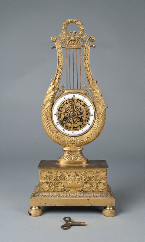 A Very Fine French Bronze Dore Mantle Clock: The lyre shaped clock on stepped squared base, topped by a Laurel wreath. The porcelain dial marked Sellier A. Paris. Sitting on four flattened bun feet. 17" H, appears to retain its' original key, cl