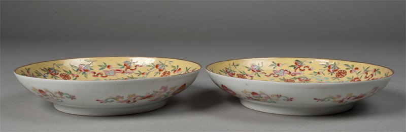 Pr. Of Chinese Famille Rose Low Bowls: Interior finely enameled in yellow ground depicting large symbol in center with colorful bats and other symbols surrounding. Exterior finely enameled with floral and scrolling designs, and with gilt r