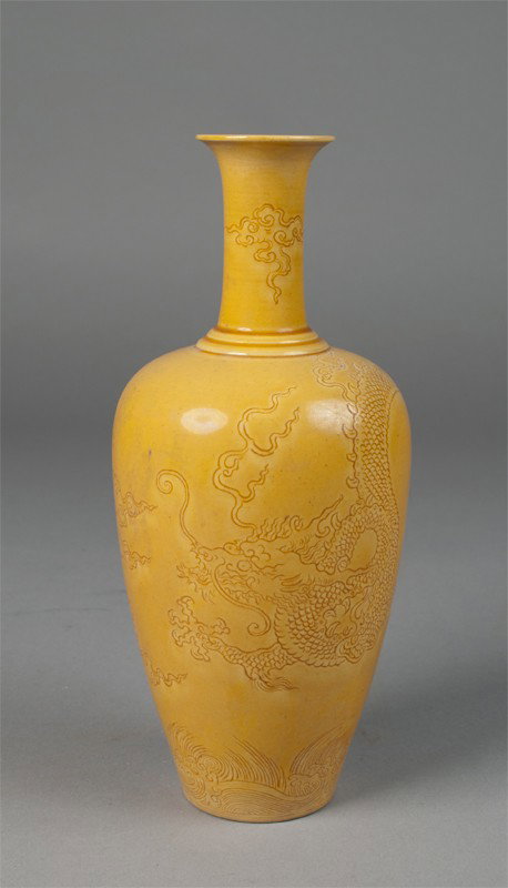 Chinese Molded Porcelain Saffron Vase: Finely molded to depict a large dragon and ruyi clouds. Six character mark in underglaze blue on underside. 9.5" H, circa 20th century.