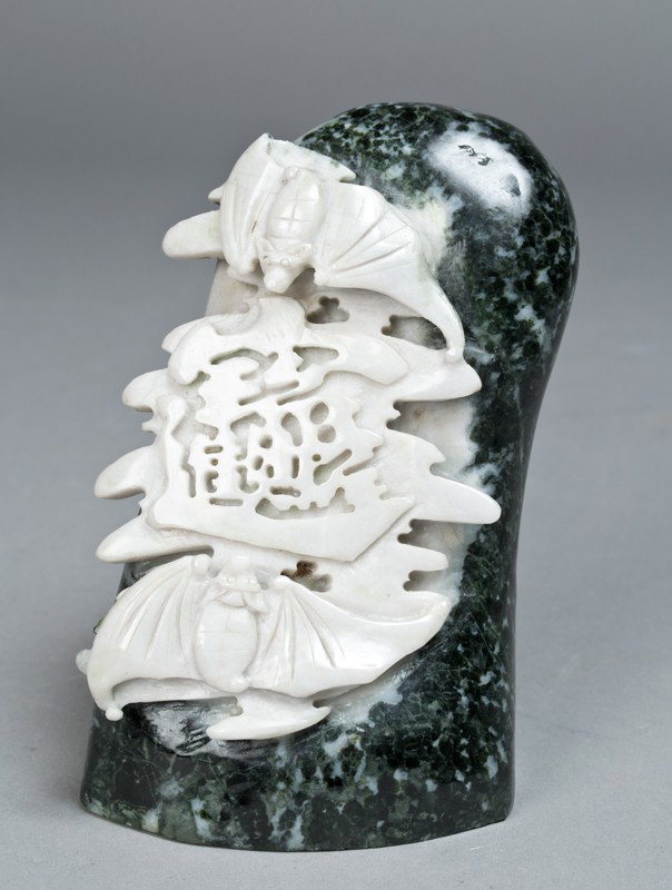 A Fine Chinese Hardstone Carving of Bats: Green and white mottled stone with carving in white of bats and symbol. 5" H x 3.25" W, circa 20th century.