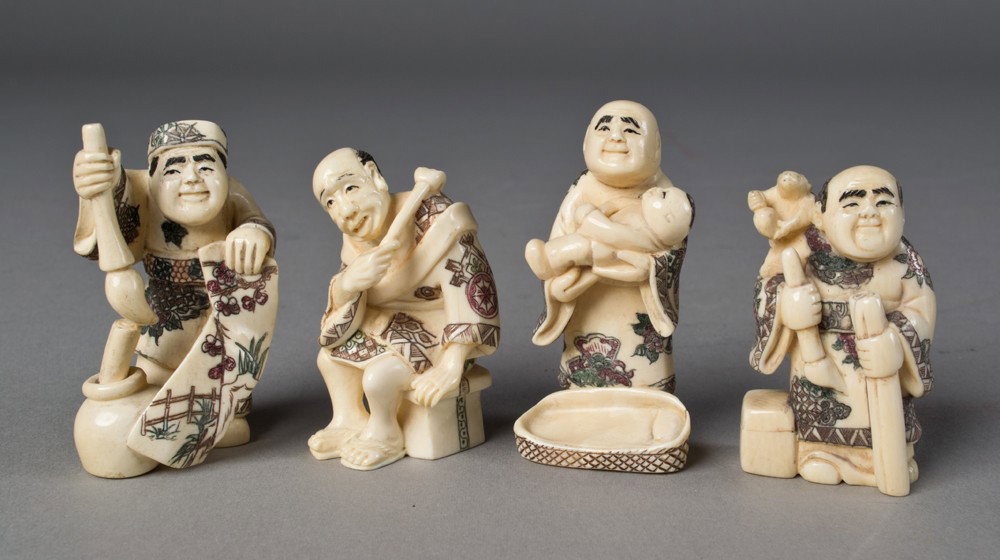 (4) Japanese Ivory Netsuki's: All finely carved in various poses all with ink and painted highlights largest is 2.375To include various figures including a seated figure holding a mirror a standing elder holding a ruyi scepter in 
