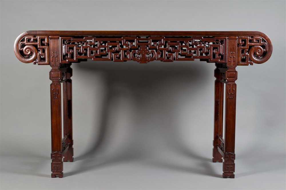 A Fine Chinese Hardwood Alter Table: Possibly rosewood finely carved with scrolled ends carved aprons and legs beautiful reddish brown color, 35" H x 60" W x 17.25" D, circa 1950's, breaks down for easy shipping.
