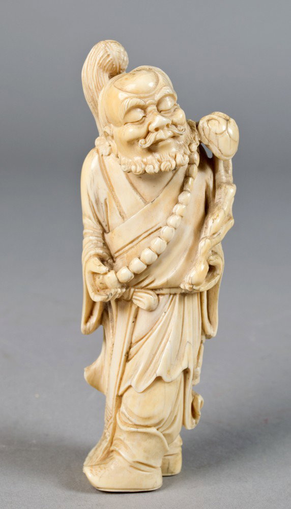 Chinese Carved Ivory Figure: Finely carved depicting an elder with prayer beads holding a ruby scepter, 5"H circa 20th century.