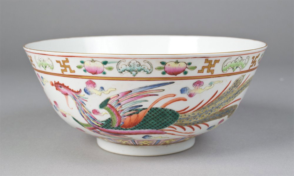 Chinese Famille Rose Bowl: Finely enameled to depict a dragon and a Phoenix chasing a flaming pearl, with peach, symbol and bat designs at top, and stiff petals at bottom. Six character mark in iron red on underside. 3.25" H x 
