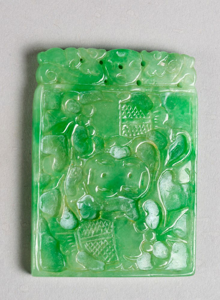 A Fine Chinese Carved Jadeite Plaque: Finely carved on both sides to depict fish and bats amongst foliage the stone an apple green with white inclusions and fine polish 2.25"H X 1.25"W circa late 19th-early20th century.
