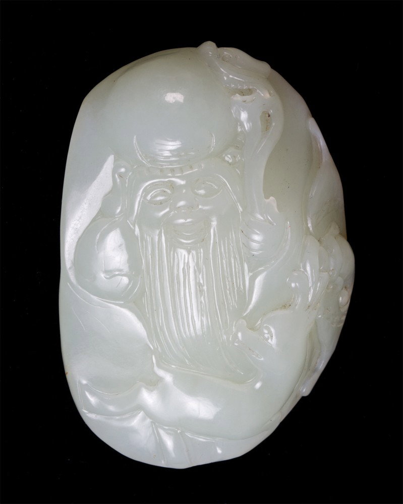 A Fine Chinese Carved Jade God of Longevity: Finely carved to depict God of Longevity with small deer at base of his beard. 2 & 1/8" L, circa 20th century.