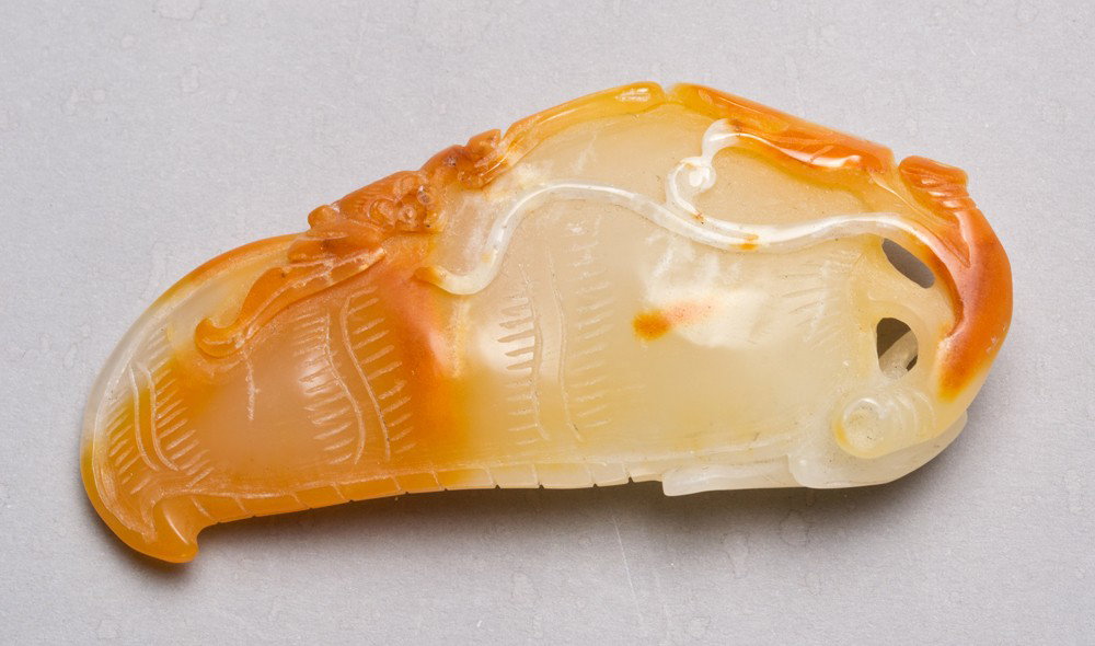 A Fine Chinese Carved Yellow Jade Gourd: Finely carved on both sides to depict a gourd with vines and leaves. 3" L, circa 20th century.